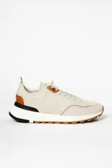 Zapatillas deportivas color beige con detalles en cuero marrón y suela de goma blanca y marrón.