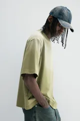 Remera de algodón color verde con efecto desteñido, corte amplio, cuello redondo y mangas cortas.