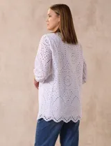 Blusa blanca de algodón con bordado broderie, cuello a la base con escote en V y mangas tres cuartos amplias con puño elastizado.