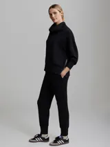 Buzo negro de corte oversize con cuello alto, mangas abullonadas, cierre lateral y hombros caídos.