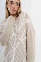 Sweater de mohair color crema con diseño de telaraña bordado a mano en negro.