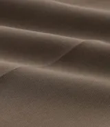 Pantalón pantalona color marrón, de corte sastrero, con pliegues delanteros y trabillas en la cintura.