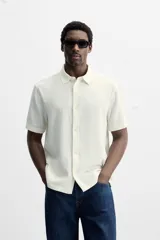 Camisa celeste de corte recto, manga corta y cuello solapa.