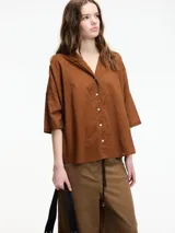Camisa color crudo con botones en la parte delantera y mangas 3/4. Corte holgado.