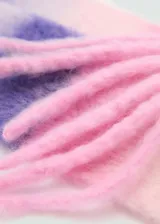 Bufanda de lana a rayas horizontales en tonos lila, rosa y blanco, con flecos en los extremos.