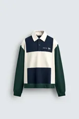 Polo de manga larga con corte relaxed fit, confeccionado en tejido con algodón. Presenta un diseño color block en azul marino, blanco y verde, con cuello solapa con cierre frontal de botonadura. Cuenta con bordados y parches combinados a contraste en delantero y espalda, y acabados en rib.