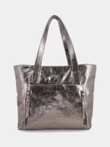 Bolso tipo shopper de mujer, color peltre (gris metálico con acabado arrugado/crush). Presenta dos asas de hombro y múltiples cierres externos con cremallera.