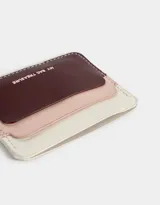 Tarjetero de cuerina con triple bolsillo colorblock en tonos blanco, rosa y bordó.