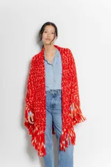 Poncho rojo con estampado y flecos, de diseño amplio y suelto.