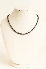 Collar corto de cuentas negras de piedra volcánica alternadas con pequeñas esferas plateadas.