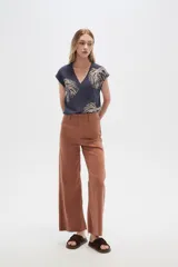 Pantalón de jean color beige, de corte flare y tiro alto, con terminación desflecada.
