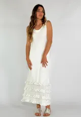 Vestido largo color amarillo, sin mangas, con escote redondo y detalle de volados en el ruedo.