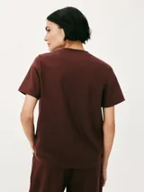 Remera color marrón claro, de corte recto, con cuello redondo y mangas cortas.