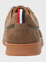 Zapatillas urbanas de cuero color marrón con detalles en verde oliva, cordones marrones y suela de goma color caramelo.