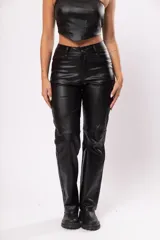 Pantalón de tiro alto negro de gabardina strech metalizada, con bolsillos y cierre frontal con cremallera y botón.