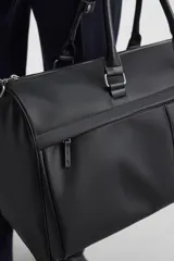 Bolso de viaje negro con textura grabada, compartimento principal con cierre de cremallera, bolsillo interior con cremallera, bolsillo frontal con cremallera, asa de hombro removible y ajustable.