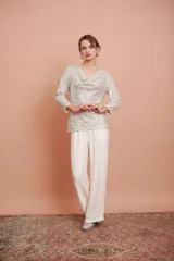 Pantalón palazzo color crudo con textura arrugada y cintura elástica.