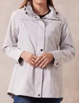Campera impermeable color gris claro, marca Gallery. Tiene abertura central con cierre oculto y botones a presión, bolsillos delanteros y capucha plegable en el cuello.