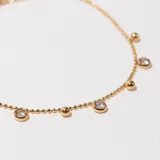 Pulsera dorada con cadena de bolitas y dijes colgantes de bolitas y circonitas engarzadas.
