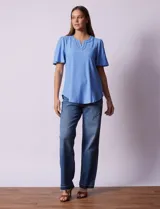 Blusa celeste de tejido piqué, con cuello a la base y escote en V. Tiene mangas cortas amplias.