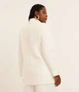 Blazer de poliéster color blanco, de corte sastrero, con cuello solapa, botón dorado redondo contrastante, manga larga con botón y bolsillos fake de solapa delanteros.