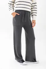 Pantalón tejido color blanco, de corte amplio y tiro alto, con bolsillos laterales y cintura con cordón ajustable.