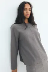 Sweater color crema de tejido suave, con cuello redondo en rib y mangas largas sin costuras.