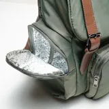 Mochila maternal color verde militar con detalles en cuero marrón. Cuenta con bolsillo térmico para biberones, cambiador, múltiples compartimentos y correas ajustables.