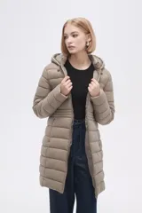 Campera acolchada color beige, de corte largo, con capucha y cierre frontal con cremallera.