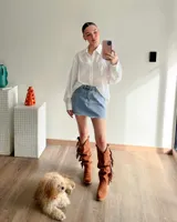 Bota tejana de caña alta color marrón tostado, confeccionada en cuero vacuno con detalle de flecos en el lateral exterior. Tiene taco de 4 cm y puntera fina. La caña puede usarse alta o arrugada.