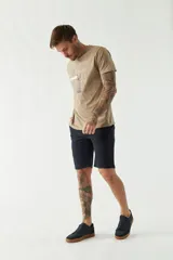 Remera color arena con estampado de edificio antiguo y texto en negro.