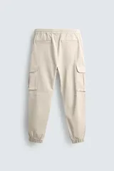 Pantalón cargo slim fit negro con cintura elástica ajustable con cordón, bolsillos frontales, traseros y laterales con solapa. Bajo con puño elástico.