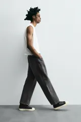 Pantalón de jean gris oscuro, corte amplio, con cinco bolsillos, efecto lavado y cierre frontal con cremallera y botón.