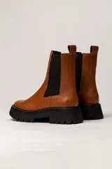 Bota Chelsea color verde militar de cuero, con elásticos laterales negros, tirador trasero y suela track negra.