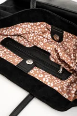 Bolso negro tipo tote bag confeccionado en gamuza vegana, con doble asa de hombro.