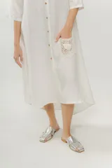 Vestido camisero azul de largo midi, con cuello mao con volados y mangas 3/4. Tiene cierre frontal con botones y un bolsillo de crochet aplicado.