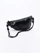Bandolera negra de cuero sintético con correa de hombro con nudos decorativos y cierre superior con cremallera.