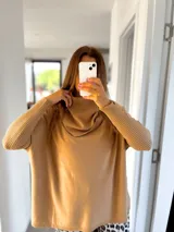 Sweater color tostado, de corte amplio y cuello alto con detalle drapeado.