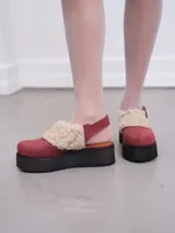 Suecos de cuero con estampado de vaca en blanco y negro, con plataforma de goma negra.