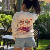 Buzo color crema de algodón con cuello redondo y mangas largas. Presenta un pequeño estampado de una lata de mermelada de frutilla en el pecho.