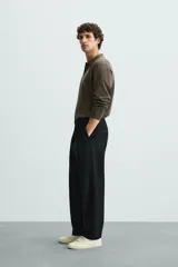 Polo de manga larga color negro, tejido en hilatura con mezcla de algodón y seda, de corte regular fit, con cuello solapa y cierre frontal de botonadura.