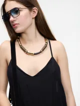 Vestido largo negro con breteles finos y bordado dorado.