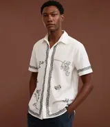 Camisa de manga corta confeccionada en algodón y lino, color blanco con bordado floral en negro.