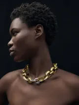 Collar de eslabones grandes metálicos, color dorado con tres eslabones plateados en el centro.
