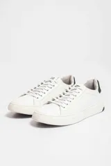 Zapatillas urbanas blancas de cuero sintético con cordones y detalle negro en el talón.