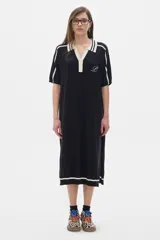 Vestido midi tejido de punto color negro, con cuello camisero blanco, escote en V y manga corta.