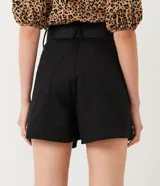 Short negro de sarga con cintura alta, trabillas, cierre con botón y cremallera, bolsillos, pliegues delanteros y cinturón con hebilla de corazón.