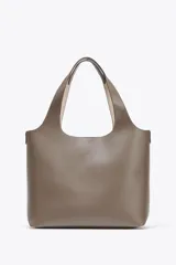 Bolso shopper de hombro color gris topo, con doble tira ancha, bolsillo interior con cierre mediante cremallera metálica y cierre imantado.