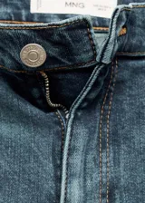 Pantalón de jean acampanado de tiro alto, color azul denim, con cinco bolsillos y trabillas.