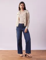 Campera color beige de algodón con cuello camisero, abertura central con botones de madera, bolsillos de parche en el pecho y mangas largas con puños abotonados.